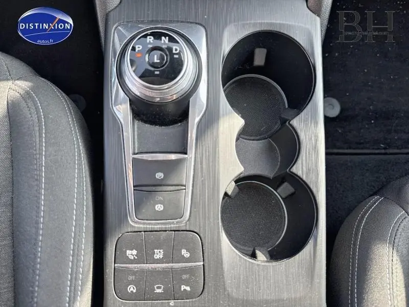 Gros plan sur la console centrale en finition gris métal brossé avec molette de boîte auto et porte-gobelets de la Ford Focus bleu azur 2019.
