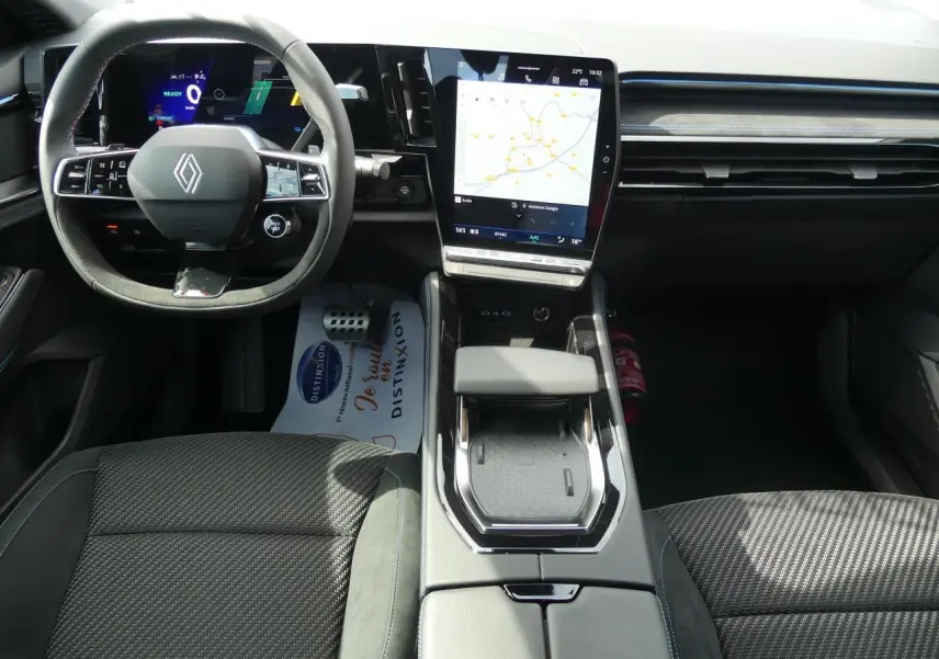 Intérieur Renault Austral 2025 vu de face, tableau de bord moderne avec écran tactile vertical et volant Alcantara noir.