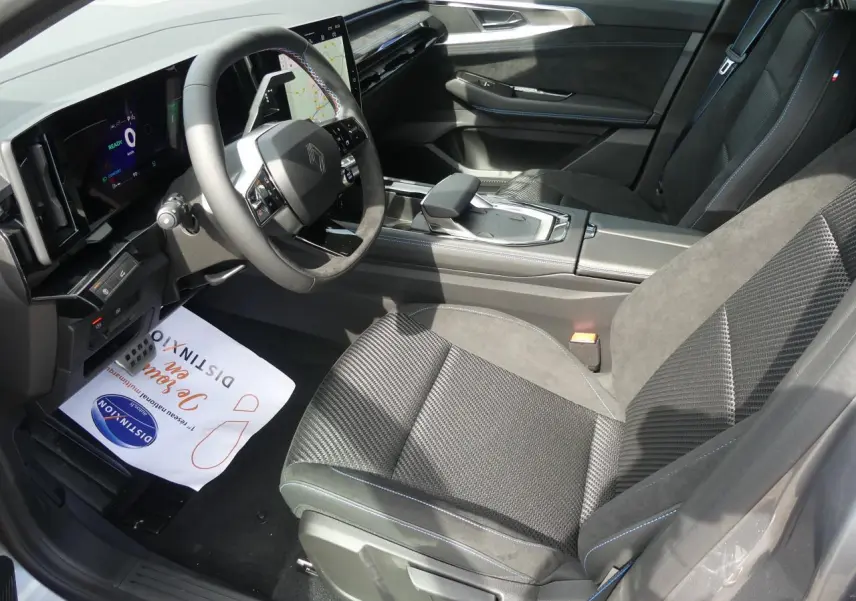 Vue intérieure côté conducteur du Renault Austral 2025 gris métallisé, avec volant Alcantara et tableau de bord numérique.