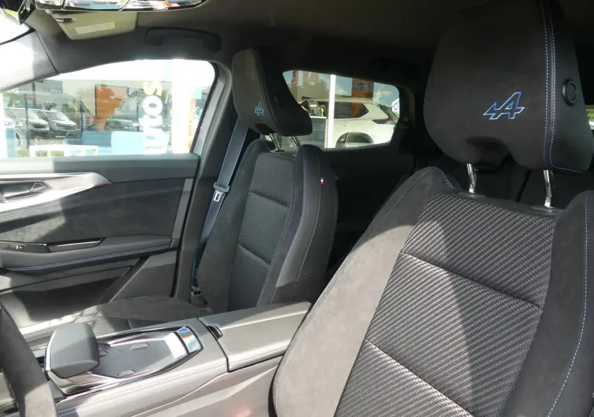 Intérieur du Renault Austral 2025, vue côté gauche sur sièges en Alcantara noir avec surpiqûres bleues et logo Alpine brodé.
