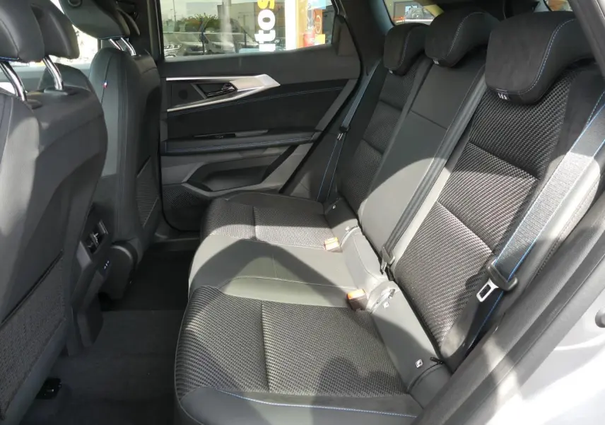 Vue latérale intérieure montrant la banquette arrière noire avec surpiqûres bleues du Renault Austral 2025 gris métallisé.