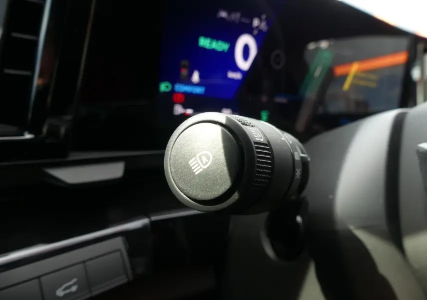 Gros plan sur la commande des feux du tableau de bord du Renault Austral 2025, intérieur noir moderne.