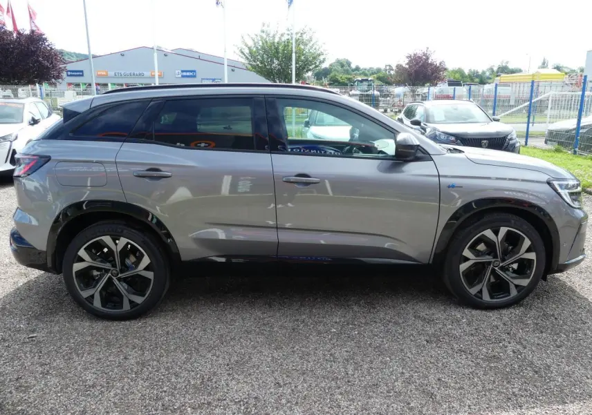 Profil côté gauche d'un Renault Austral gris métallisé avec jantes alliage 20 pouces et vitres teintées arrière.