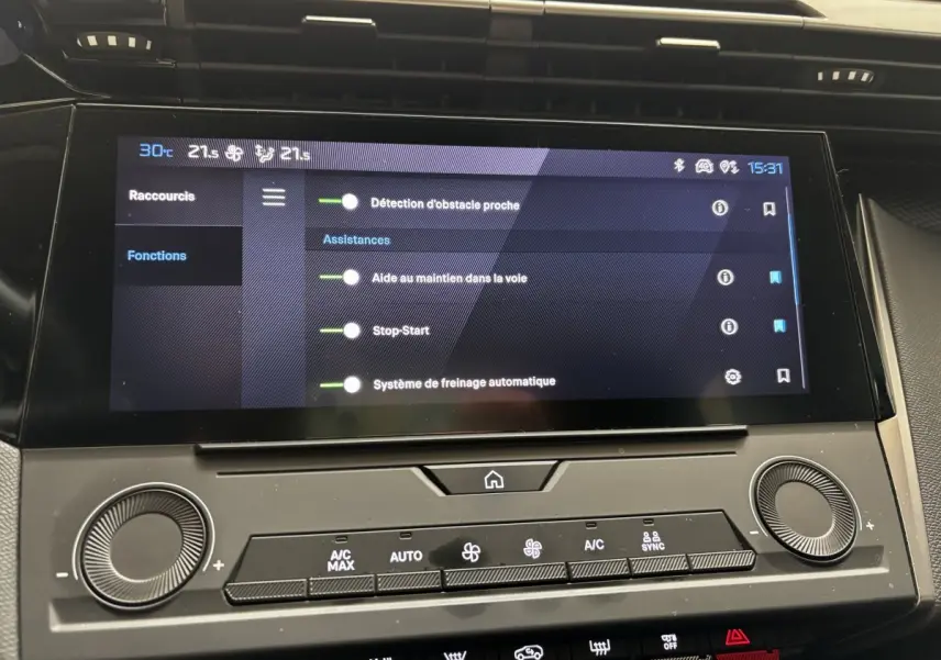 Écran tactile central affichant les aides à la conduite dans l'habitacle d'une Peugeot 308 vert 2022.