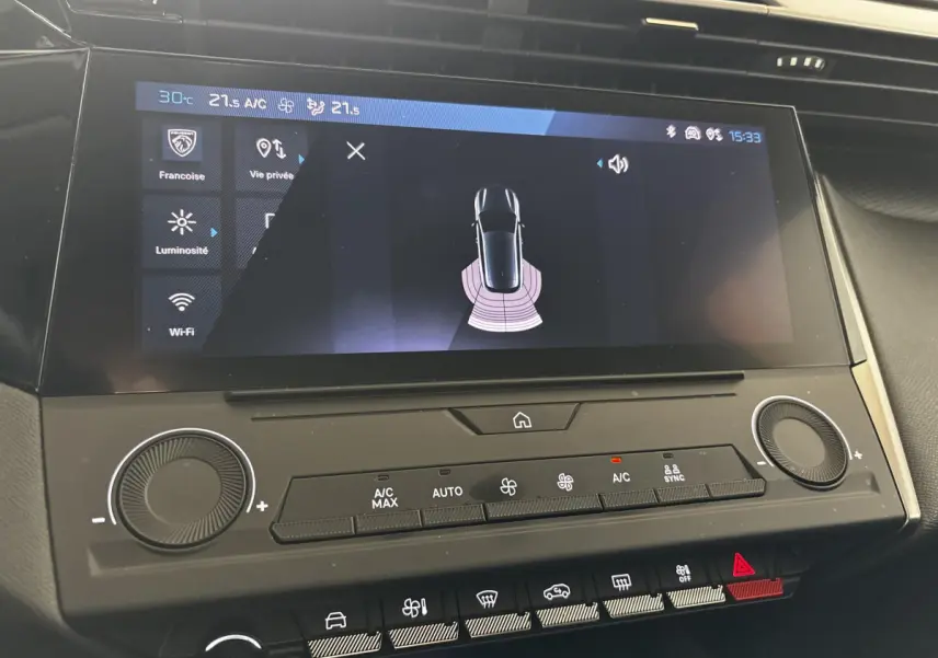 Écran tactile central de la Peugeot 308 2022 affichant l'aide au stationnement avec commandes climatisation en dessous.