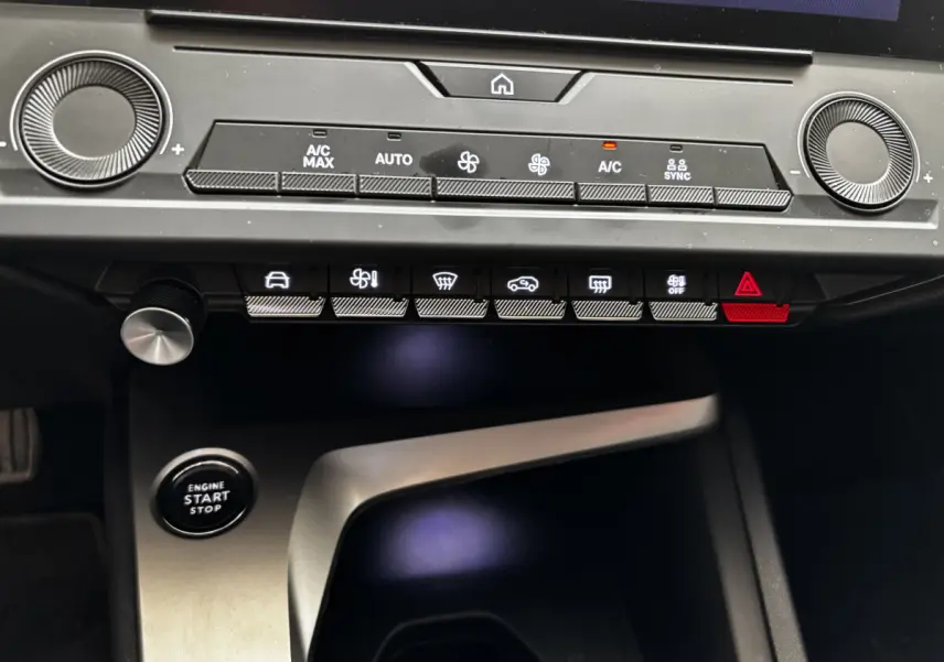 Détail du tableau de bord et console centrale de la Peugeot 308 2022 avec boutons de climatisation et démarrage sans clé.