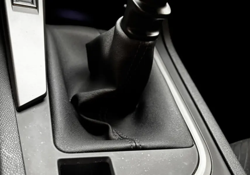 Gros plan sur la commande de boîte manuelle et frein à main électrique dans l'habitacle noir du Peugeot 308 2022.