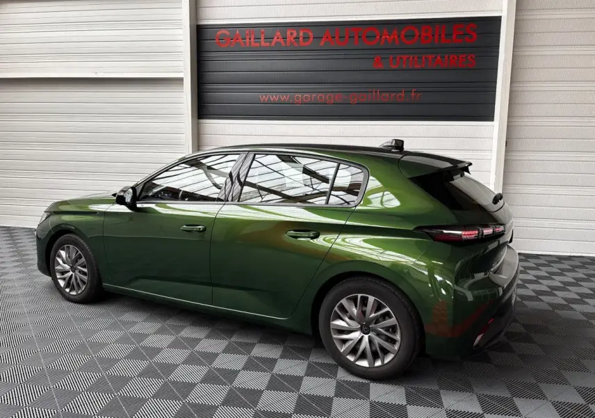 Peugeot 308 PureTech 110 S&S ACTIVE PACK vert vue de profil côté gauche dans un showroom avec sol damier.