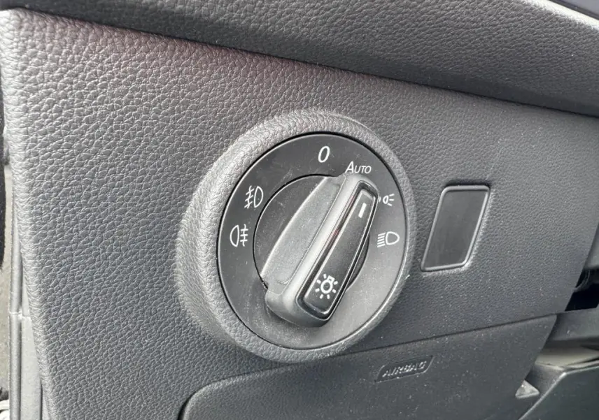 Gros plan sur le bouton de commande des phares dans l'habitacle noir du SEAT Ateca 2023 version Style.