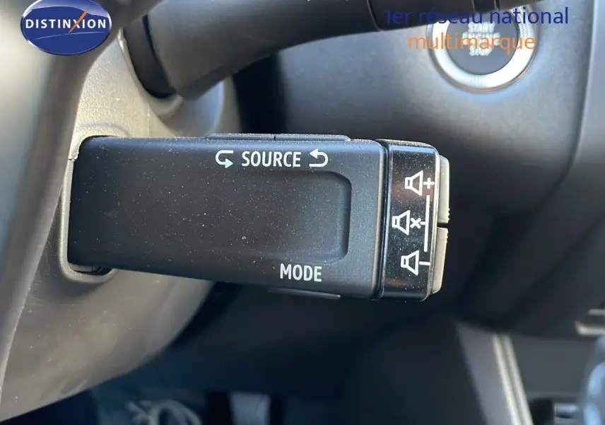 Gros plan sur la commande au volant du Renault Captur E-Tech Hybrid 2025, avec bouton source et mode visibles.