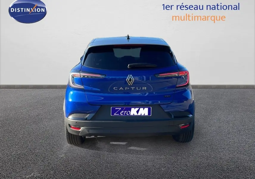 Vue arrière d'un Renault Captur E-Tech hybride bleu Iron Metal avec toit gris, feux LED et logo central bien visibles.