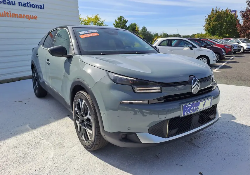 Citroën C4 hybride 145 e-DCS6 Max 2025 en Manhattan Green, vue 3/4 avant avec calandre et phares distinctifs.