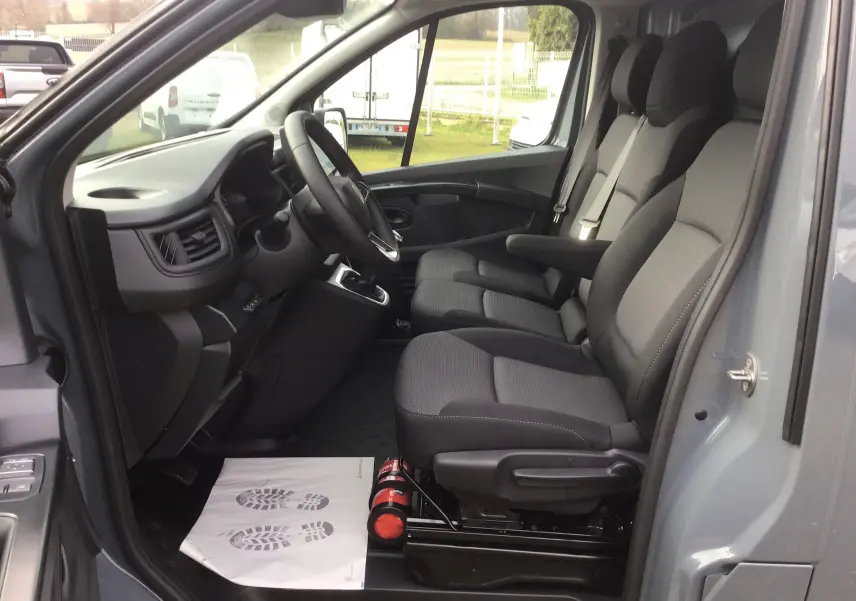 Vue intérieure côté conducteur du Renault Trafic Fourgon gris urbain 2025, montrant les sièges avant et le tableau de bord.
