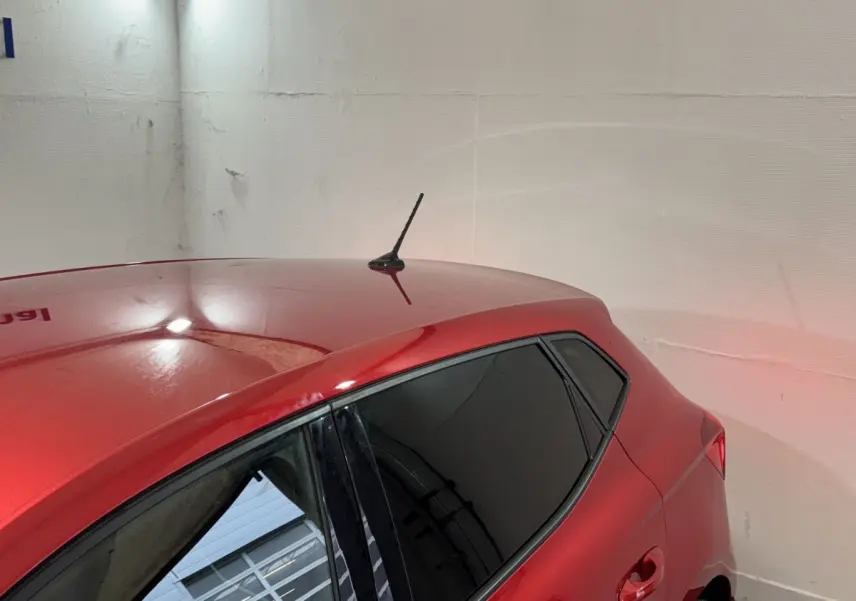 Vue arrière côté gauche d'une SEAT IBIZA 1.0 TSI 110 FR rouge avec vitres teintées et antenne sur le toit