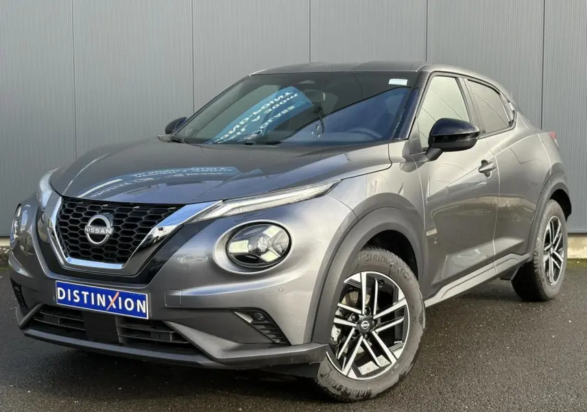 Nissan Juke 2025 gris foncé en 3/4 avant droit, avec jantes alliage diamantées et calandre chromée.