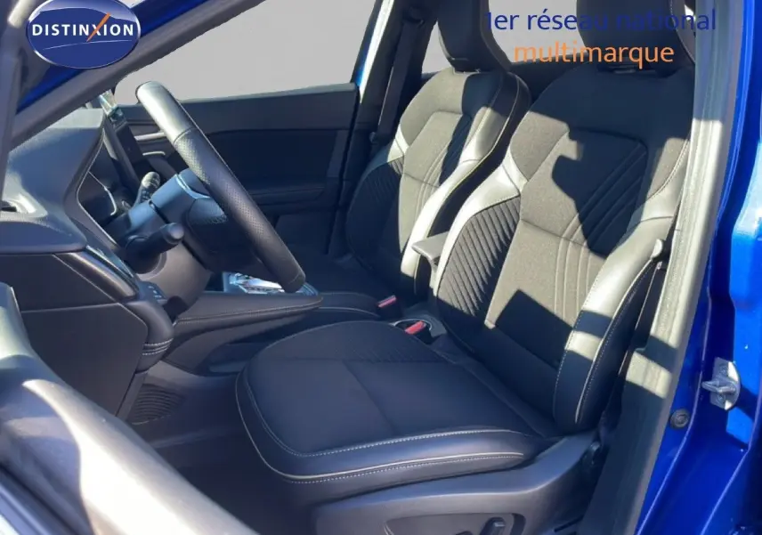 Vue intérieure côté conducteur du Renault Symbioz bleu iron metal 2025, sièges noirs avec surpiqûres blanches et volant cuir.