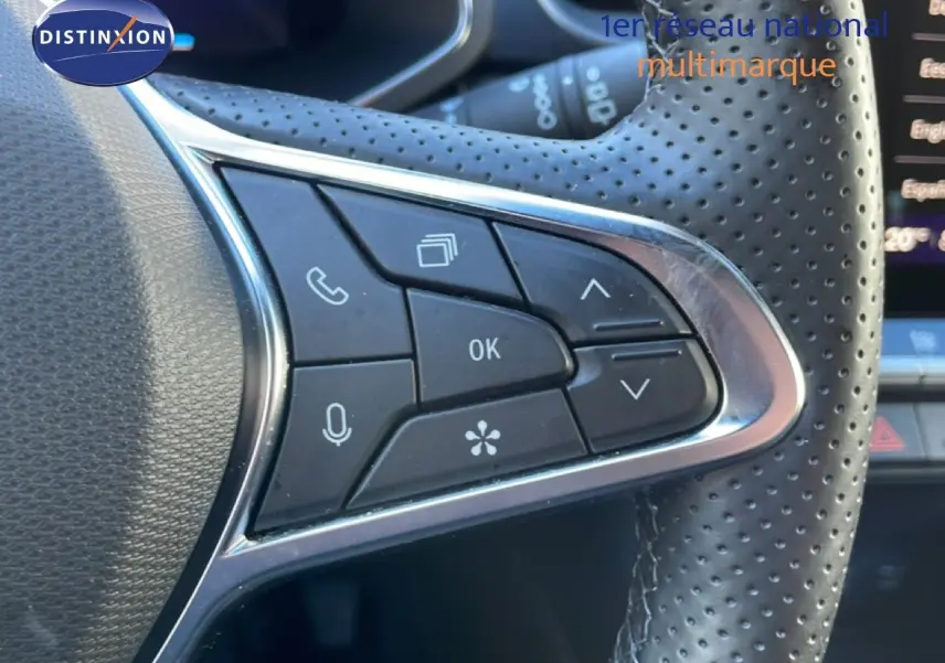 Gros plan sur les commandes au volant en cuir perforé du Renault Symbioz bleu Iron Metal, version hybride 2025.