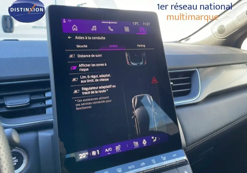 Vue intérieure centrée sur l'écran tactile du tableau de bord du Renault Symbioz bleu Iron Metal, affichant les aides à la conduite.
