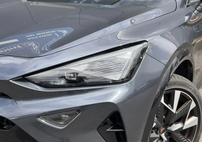 Gros plan sur l'avant droit du CUPRA Formentor gris magnétique, mettant en valeur le phare Tri-LED et la jante alliage 19 pouces.