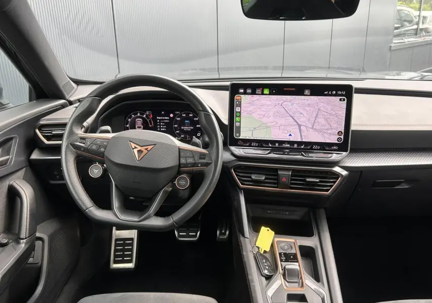 Vue intérieure avant du CUPRA Formentor gris magnétique, avec volant cuir, écran tactile central et tableau de bord numérique.
