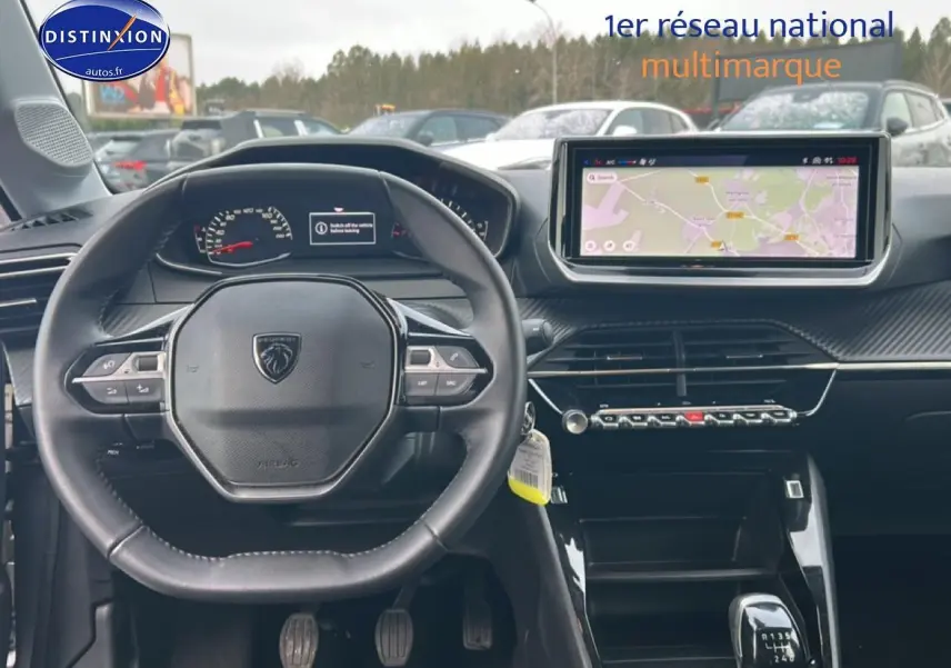 Vue intérieure frontale du poste de conduite de la Peugeot 208 gris Artense avec écran tactile et volant compact.