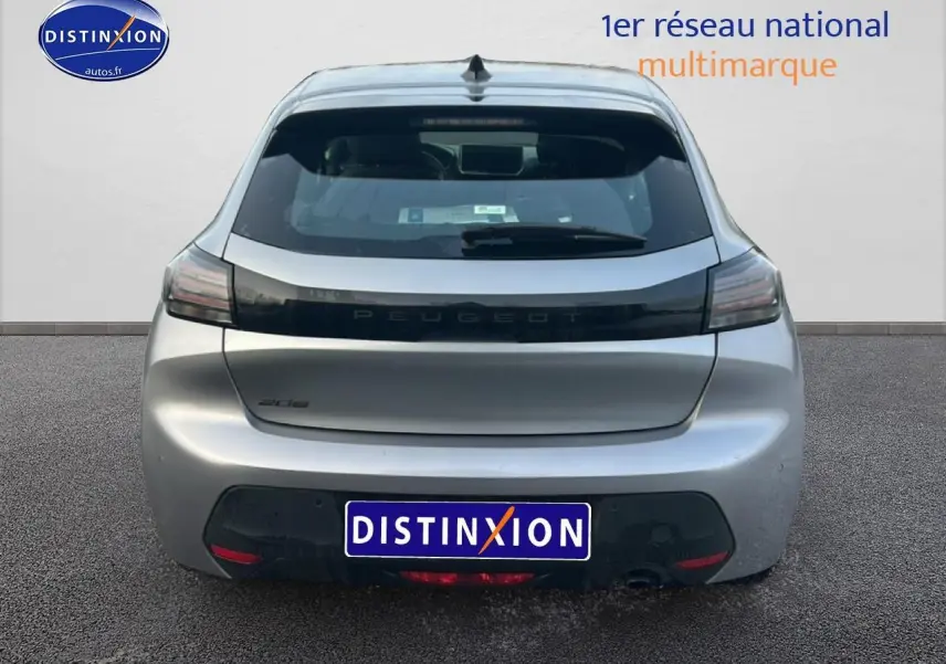 Vue arrière d'une Peugeot 208 gris artense 2025 avec feux arrière sombres et logo Peugeot central sur hayon.