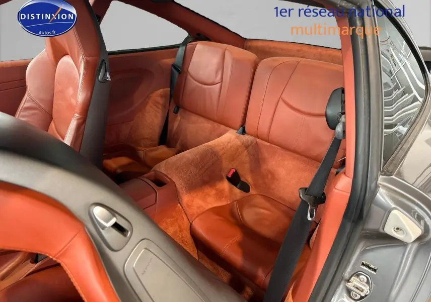 Vue intérieure arrière droite de la Porsche 911 (997) carrera pdk 2009 avec sellerie cuir marron et moquette assortie.