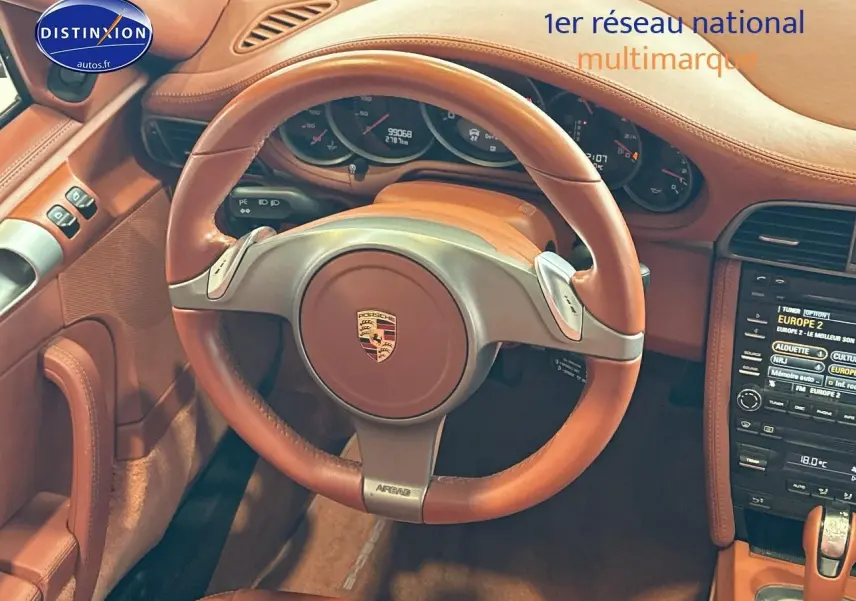 Intérieur cuir marron de la Porsche 911 (997) carrera pdk de 2009, vue centrée sur le volant et le tableau de bord.