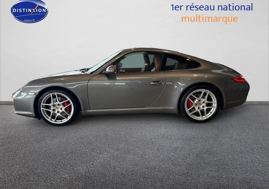 Profil côté gauche d'une Porsche 911 (997) Carrera PDK gris métallisé avec jantes alu et étriers rouges.