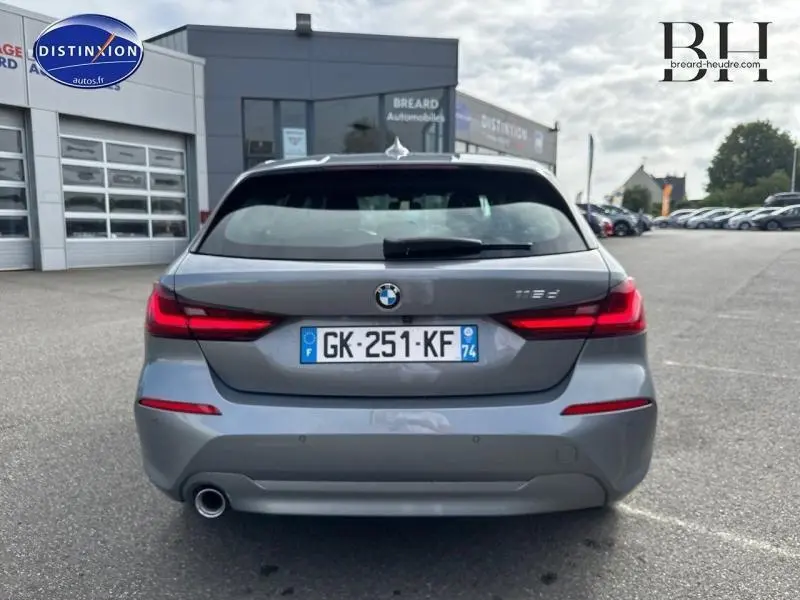 Vue arrière d'une BMW Série 1 116dA gris Skyscraper métallisé avec feux LED et sortie d'échappement chromée visible.