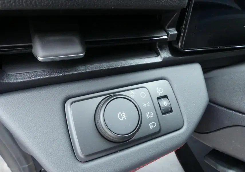 Gros plan sur la commande des feux avec molette et réglage d'intensité dans le tableau de bord du Ford Puma 2025 gris métallisé.