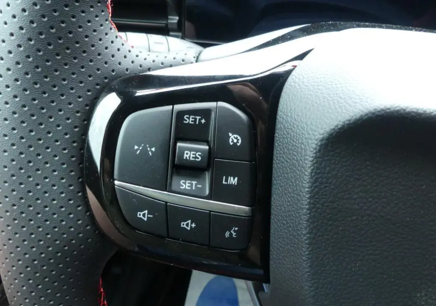 Gros plan sur les commandes du volant perforé avec surpiqûres rouges du Ford Puma 2025 finition ST-Line.