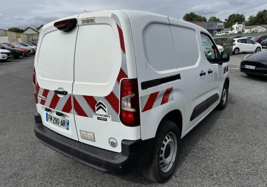 Vue 3/4 arrière droite du Citroën Berlingo blanc avec bandes réfléchissantes rouges et pare-chocs noirs.