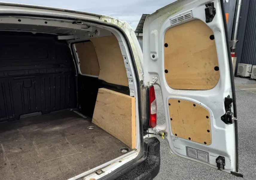 Vue intérieure arrière du Citroën Berlingo blanc avec portes battantes ouvertes et aménagements en bois dans la zone de chargement.