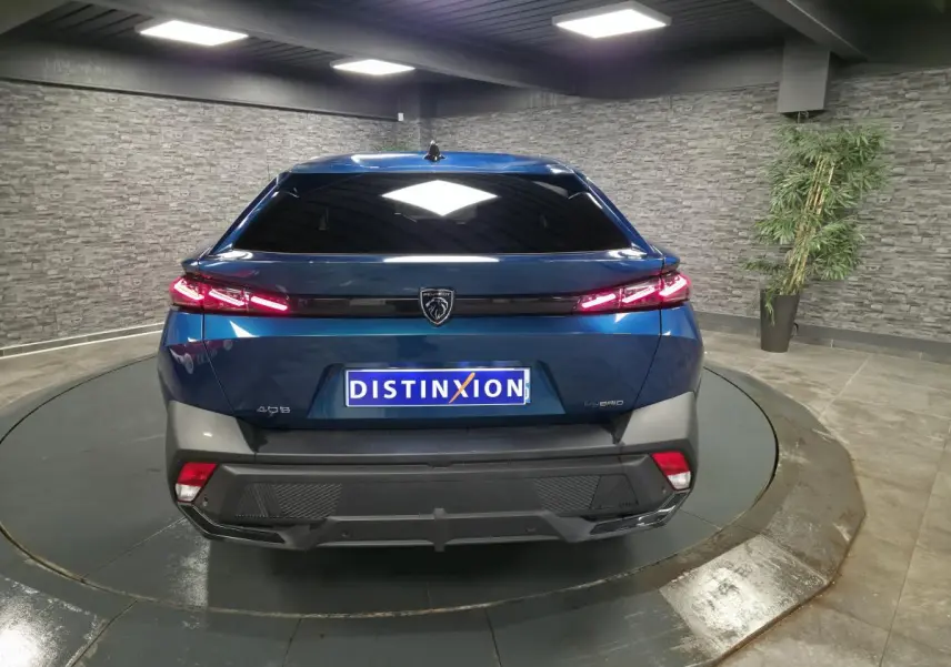 Vue arrière d'une Peugeot 408 hybride rechargeable bleu métallisé, avec feux arrière à LED et logo lion central.