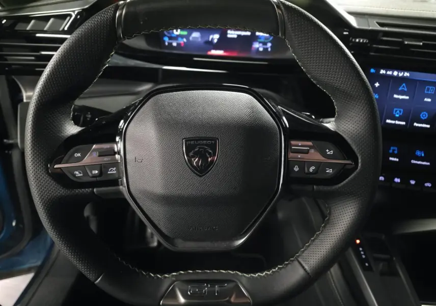 Vue rapprochée du volant cuir perforé noir avec logo Peugeot et commandes intégrées du Peugeot 408 GT 2024.