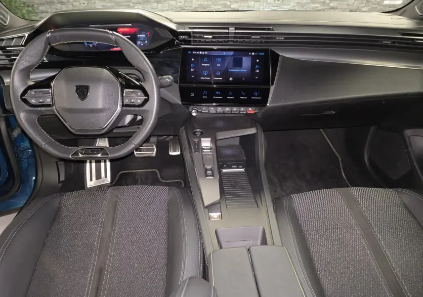 Vue intérieure avant de la Peugeot 408 GT 2024, tableau de bord noir avec écran tactile 10 pouces et volant compact.