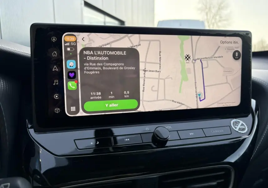 Écran tactile central du Nissan Juke 2024 affichant un itinéraire avec interface Apple CarPlay en intérieur noir brillant.
