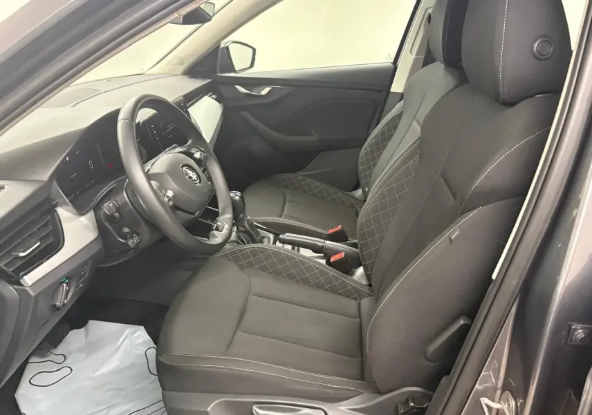 Intérieur de la SKODA KAMIQ 2023 en gris graphite, vue côté gauche sur les sièges avant et le tableau de bord moderne.