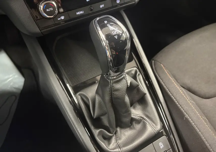 Gros plan sur le levier de vitesses automatique du Skoda Kamiq 2023, finition Business, avec sellerie noire et coutures contrastées.