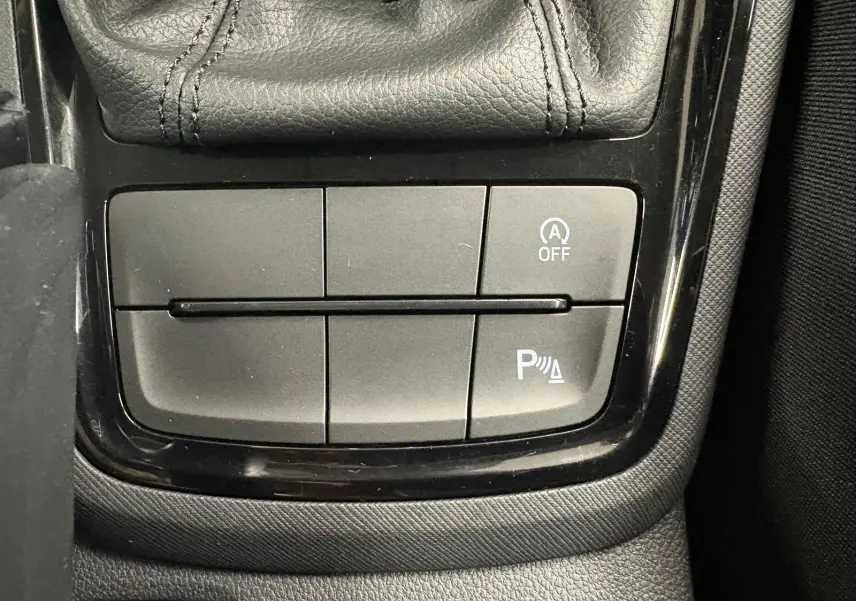 Gros plan sur les commandes près du levier de vitesse d’un Skoda Kamiq 2023, finition Business, intérieur noir.