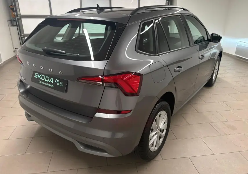 Vue 3/4 arrière droite d'un Skoda Kamiq 2023 gris graphite métallisé, avec feux arrière LED et jantes alliage.