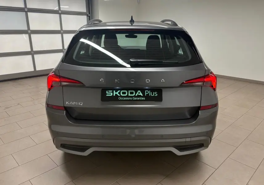 Vue arrière d'un Skoda Kamiq 2023 gris graphite avec feux LED et logo ŠKODA bien visibles dans un garage.