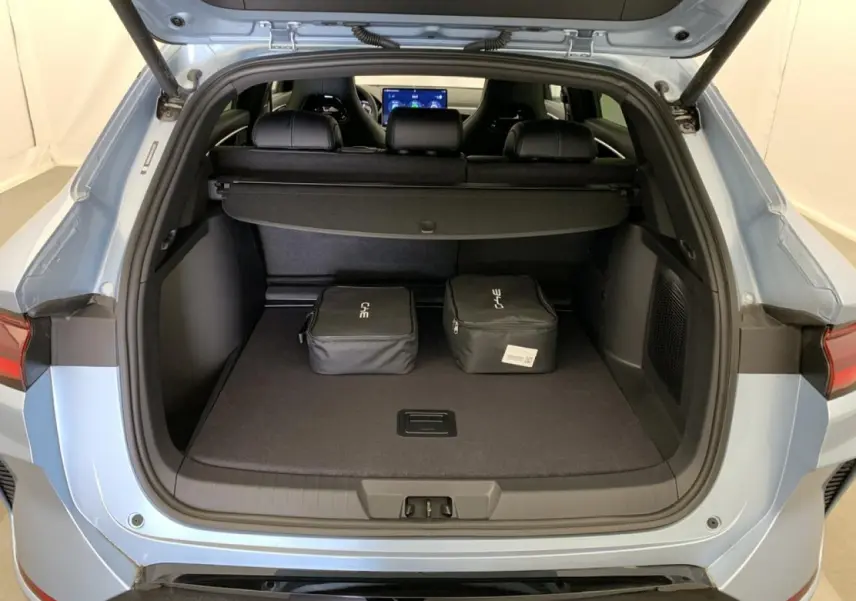 Coffre ouvert vu de l'arrière du BYD SEAL U 1.5 DM-i 2025 en bleu Tian Qing avec deux sacs de rangement noirs.
