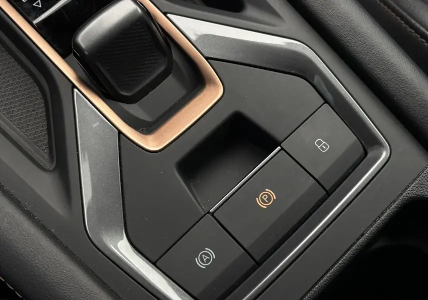 Gros plan sur la console centrale noire du CUPRA Formentor avec boutons de frein à main électrique et verrouillage.