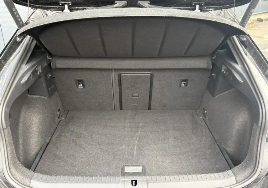 Coffre ouvert vu de l'arrière d'un CUPRA Formentor Noir Minuit avec intérieur de coffre en tissu gris.