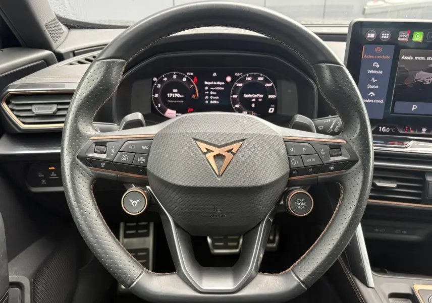 Vue rapprochée du volant perforé noir avec logo CUPRA cuivré et tableau de bord numérique du Formentor 2025.