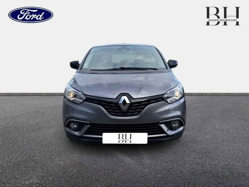 Vue de face du Renault Scénic 1.7 Blue dCi 120ch Limited gris Cassiopée avec calandre noire et phares allumés.