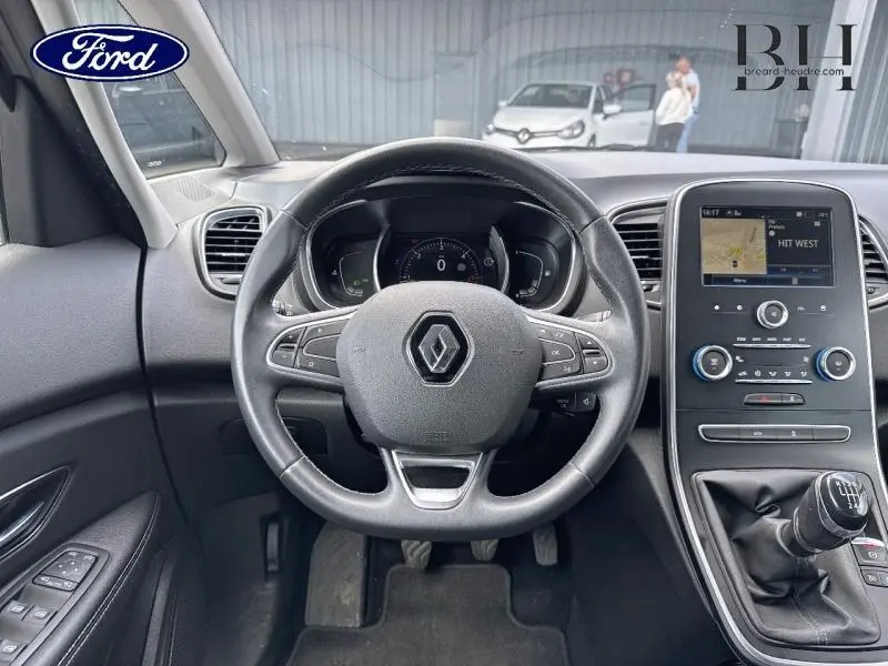 Vue intérieure centrée sur le volant cuir et la console tactile d'un Renault Scénic 1.7 Blue dCi gris Cassiopée/Noir Etoilé.