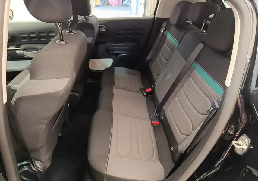 Vue intérieure côté droit sur la banquette arrière grise avec bandeau vert d'une Citroën C3 noire 2022.